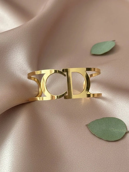 Women wearing golden cuff bracelet
