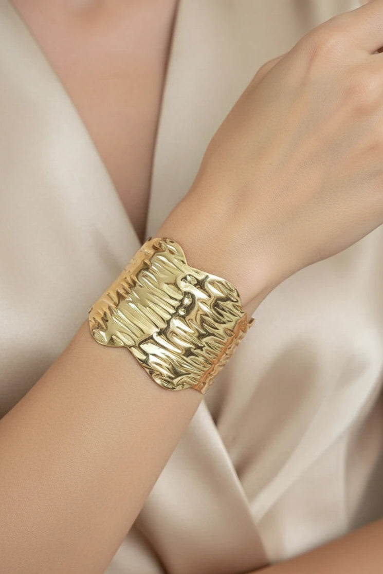 Women wearing golden cuff bracelet
