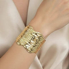 Women wearing golden cuff bracelet
